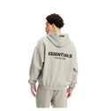 Person wearing grey hoodie in a white background 