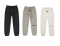 Three pairs of sweatpants in black, gray, and white on a white background