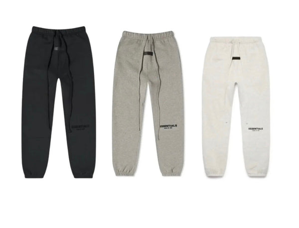 Three pairs of sweatpants in black, gray, and white on a white background