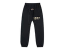 Black cuffed sweatpants with a white design 